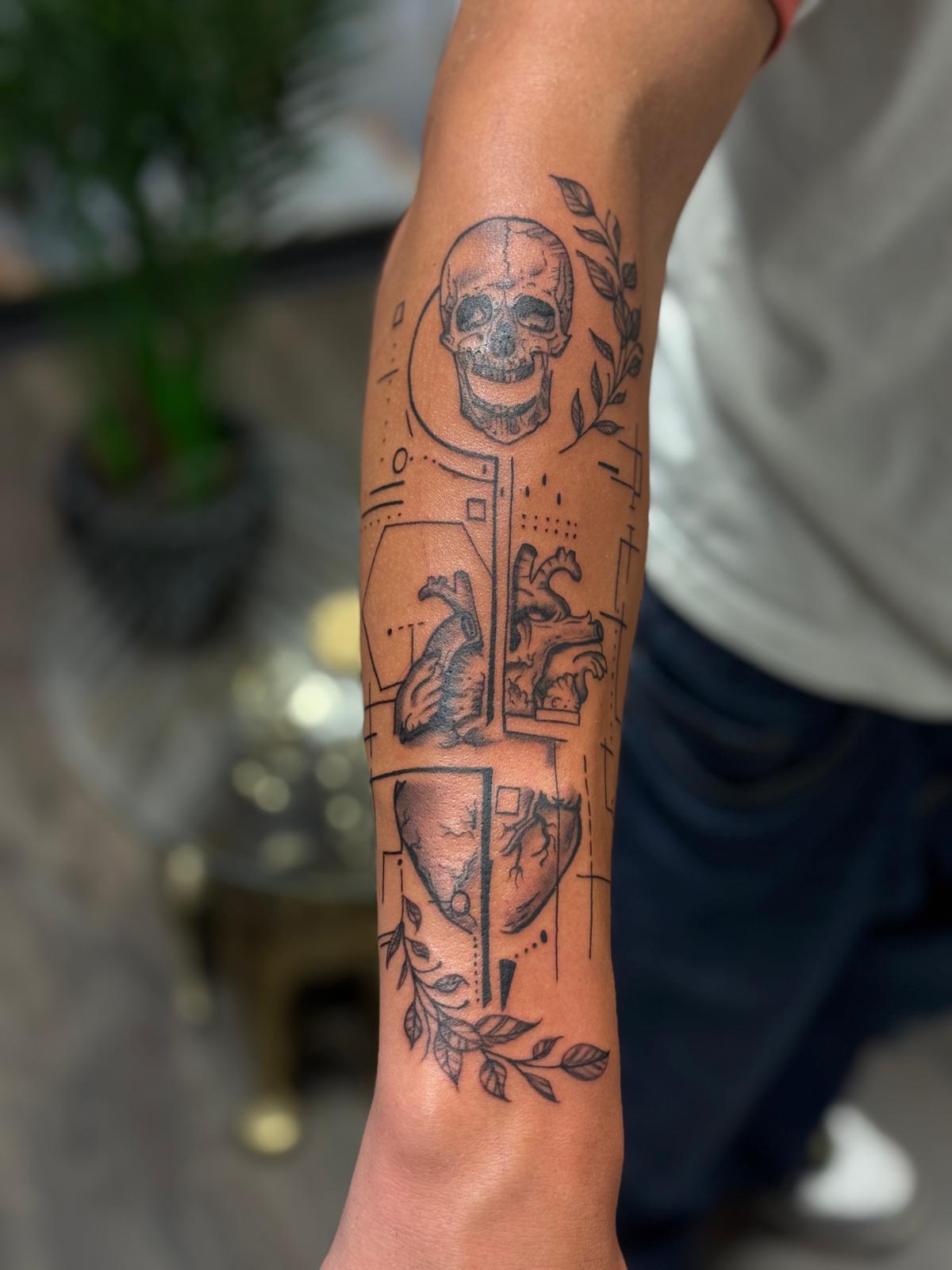 Detailed skull and heart sleeve tattoo